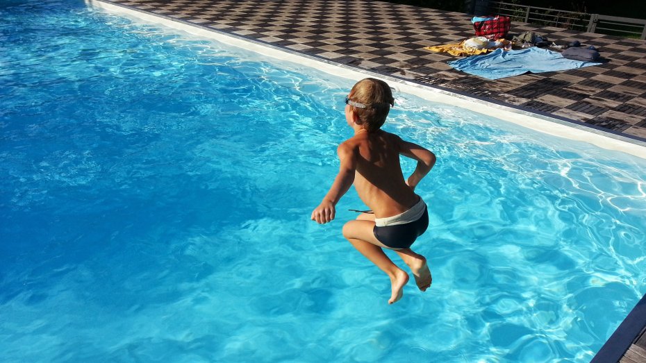 Kind springt in Schwimmbecken