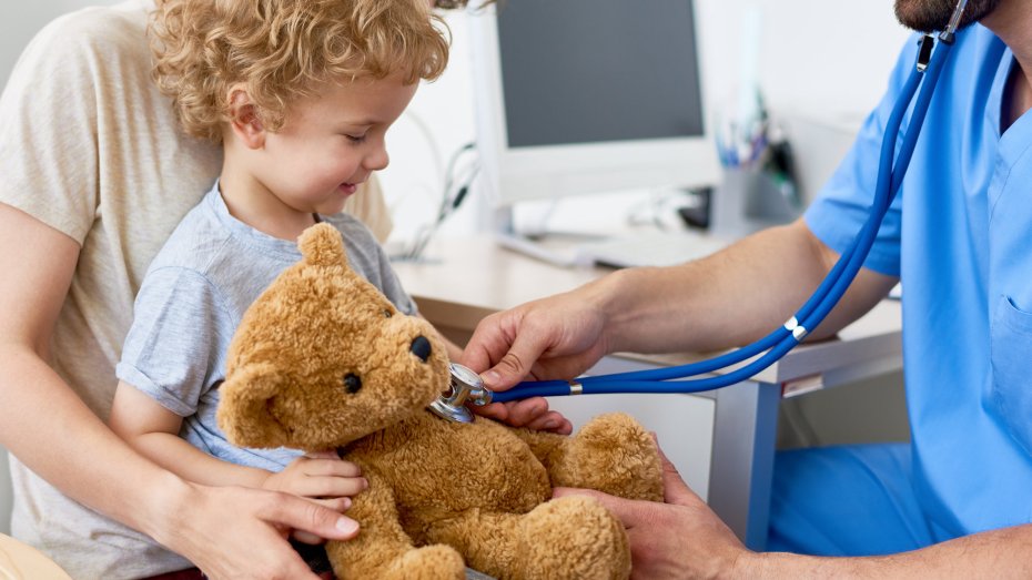 Kind mit Teddybär beim Kinderarzt