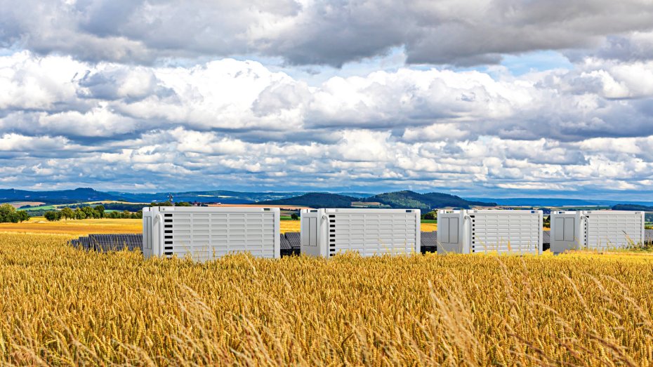 Symbolbild: Batteriespeicher und Solaranlagen an einem Feld