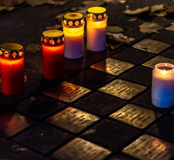 Symbolbild: Stolpersteine mit Kerzen daneben